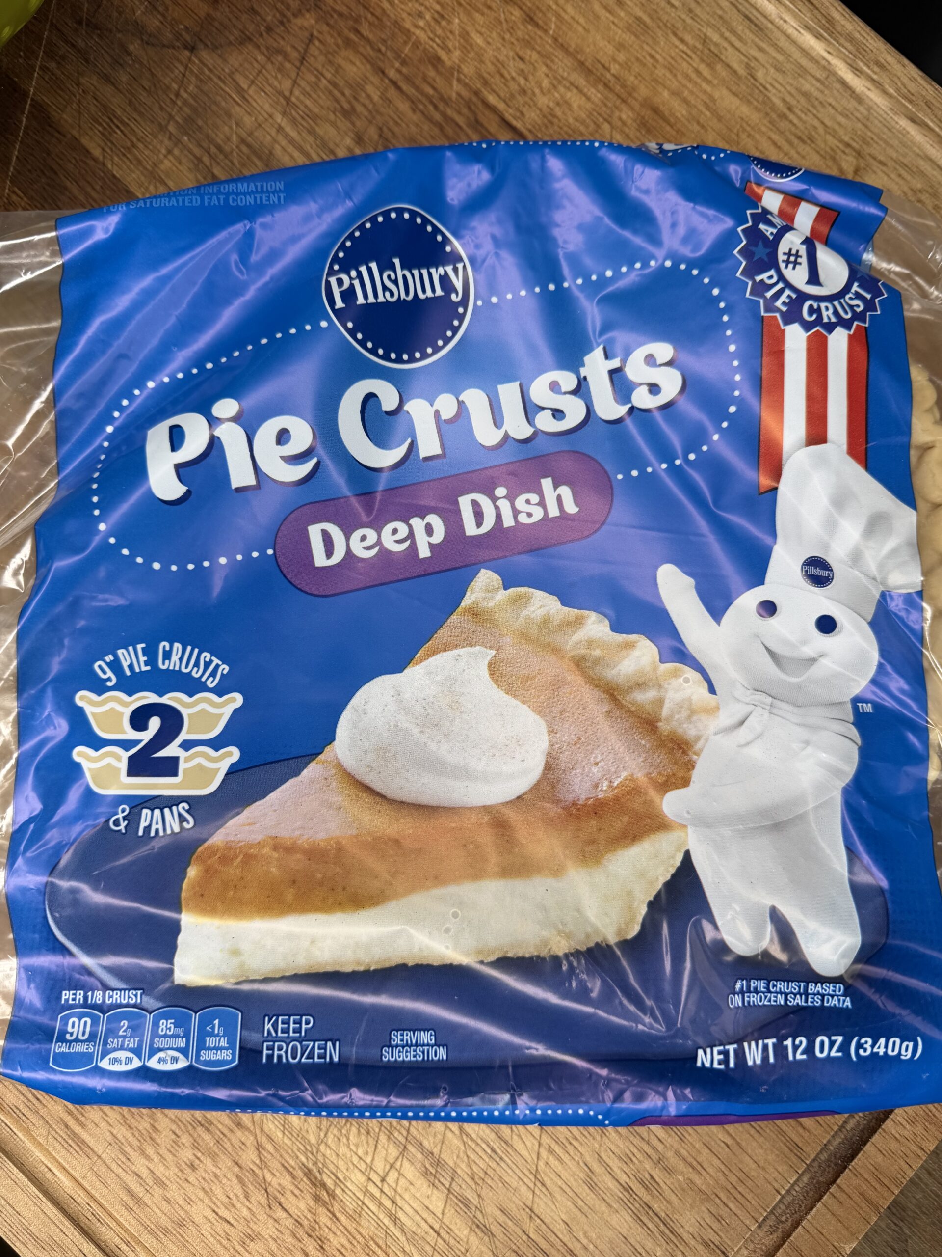 A package of Pillsbury Deep Dish Pie Crusts, perfect for making recipes like Grandma Jo's Artichoke Quiche. Features an image of pie with whipped cream and the Pillsbury Doughboy. Contains 2 crusts, 2 pans, net weight 12 oz (340g).