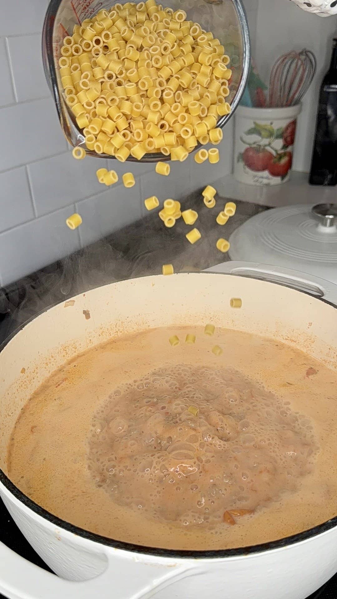 A pot of pasta being poured into a pot.