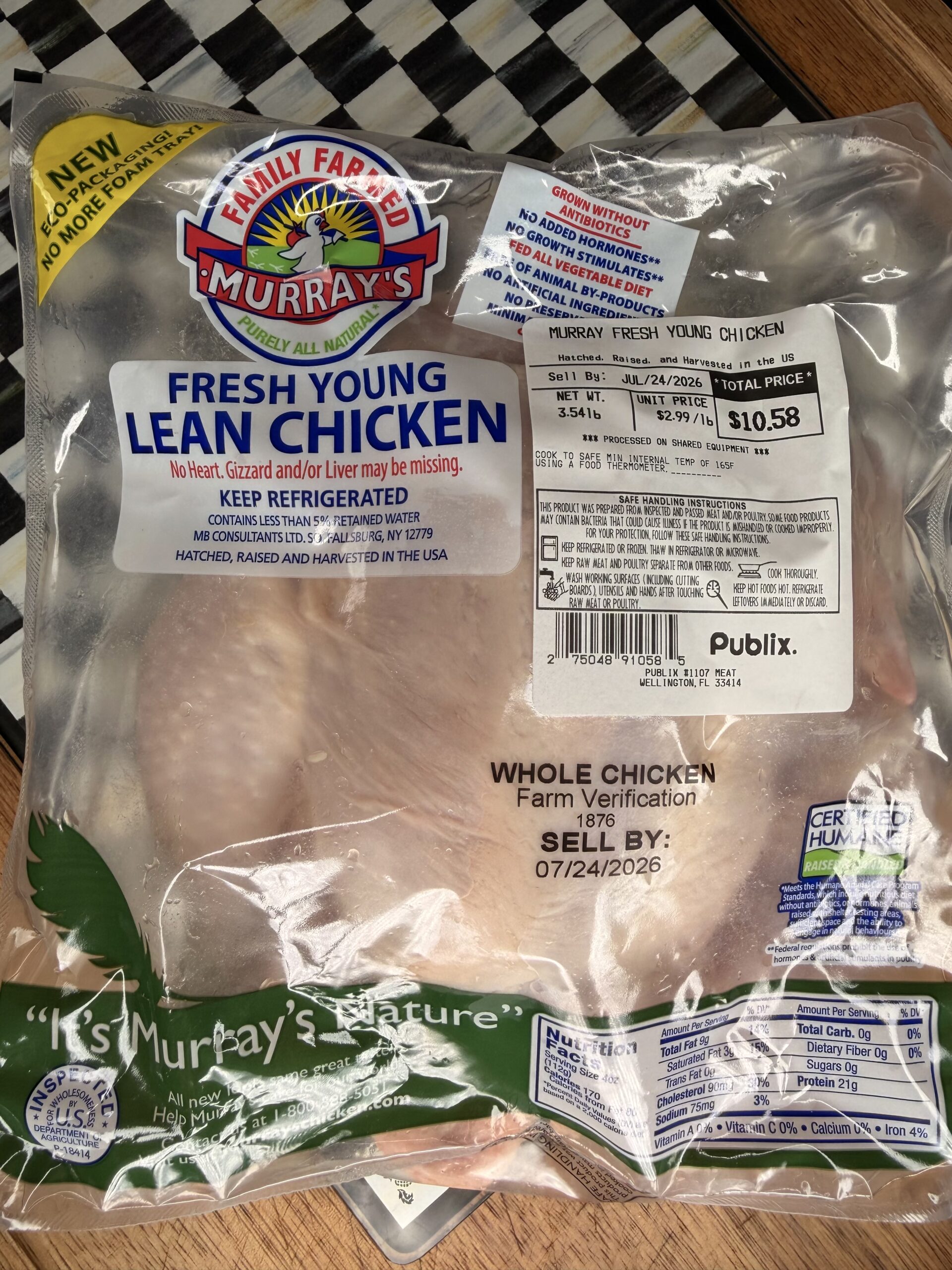 A packaged Murray’s fresh young lean whole chicken from Publix, labeled with weight, price, and expiration date, on a checkered surface.