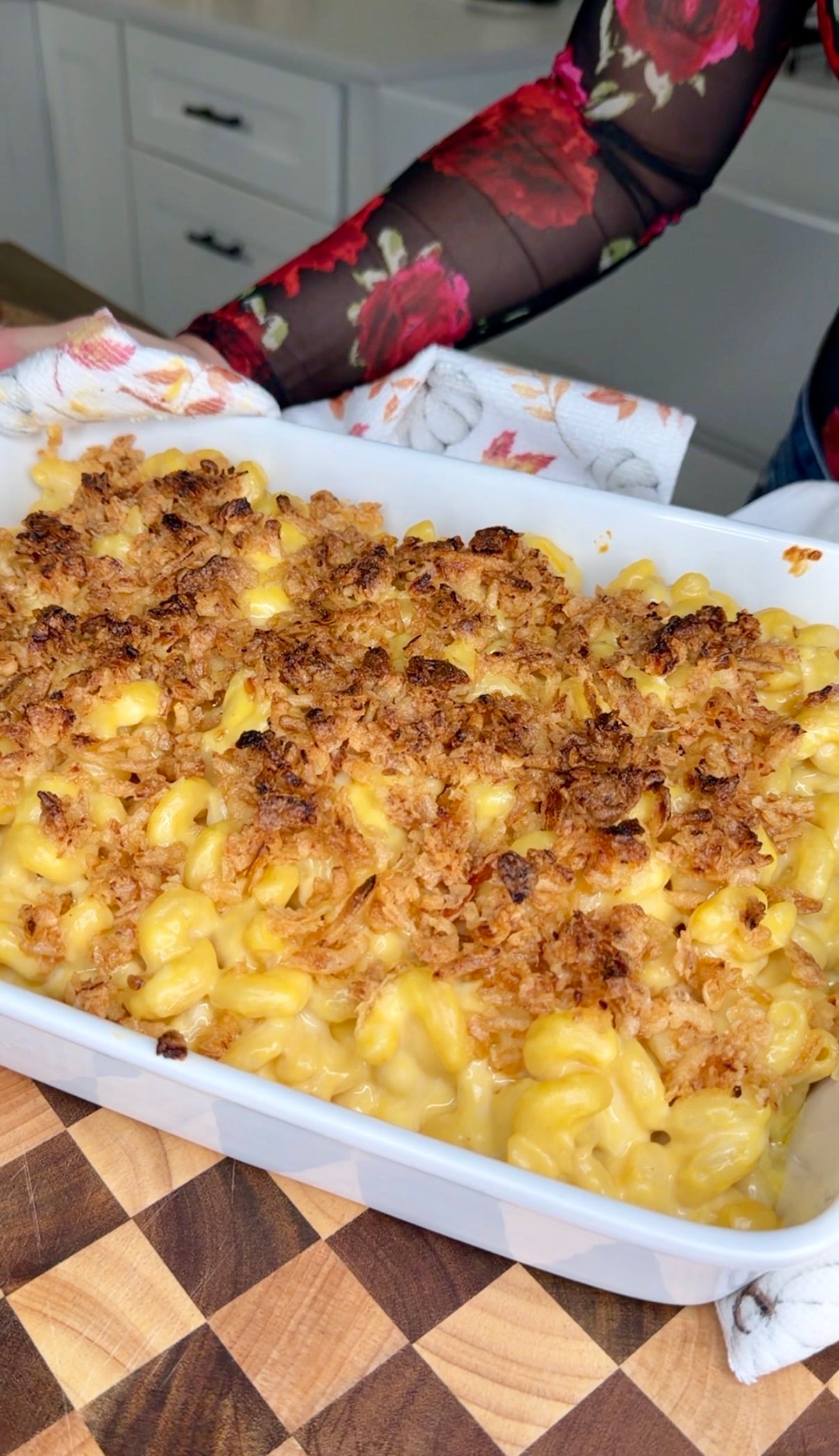 Baked macaroni and cheese with a golden-brown breadcrumb topping in a white casserole dish.