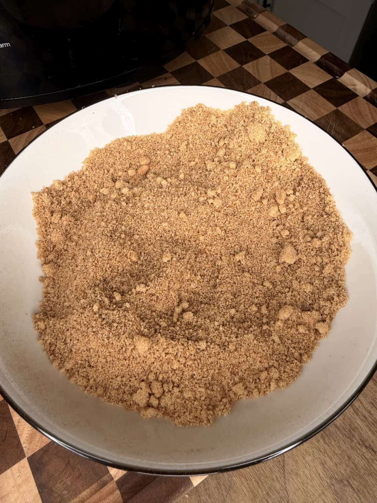 A white bowl filled with light brown crumbs.