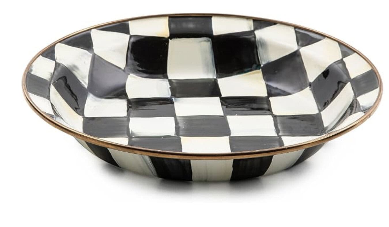 A shallow, wide bowl with a hand-painted black and white checkered pattern and a thin metallic rim.